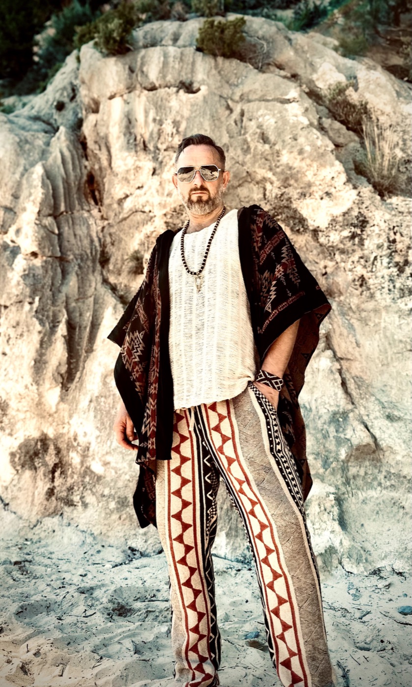 Xaguar in a poncho in front of a white cliff